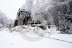A tractor shoveling snow from a mountain road in the Carpathians photo