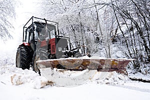 A tractor shoveling snow from a mountain road in the Carpathians photo