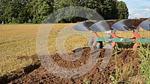 Tractor slowly ploughing farm field soil