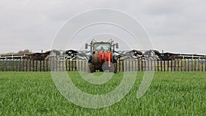 Tractor with a slurry spreader Dribble Bar in a field. UK