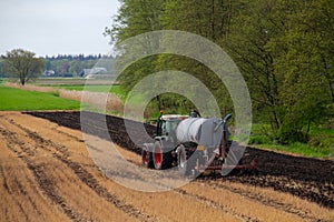 Tractor with slurry tank preparing field treated with glyphosate for cultivation