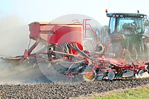 Tractor sowing or drilling seed.