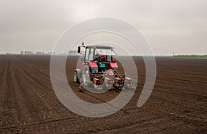 Tractor sowing field in spring time