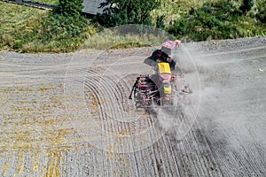 Tractor sows in the field top view from a drone