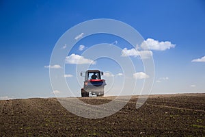 Tractor Spaying a field in the spring photo