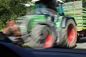 Tractor speeding past a car