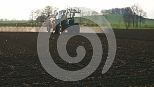 Tractor spray fertilize on field with chemicals in agriculture field.