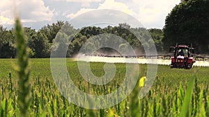 Tractor spray fertilize field with chemicals for crop protection