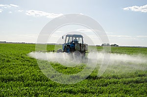 Tractor spray fertilize field pesticide chemical photo