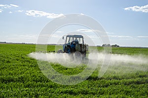 Tractor spray fertilize field pesticide chemical photo