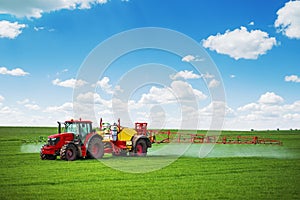 Tractor spray fertilizer spraying pesticides on green field, agriculture background concept