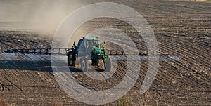 Tractor spray fertilizer spraying pesticides on green field, agriculture background concept