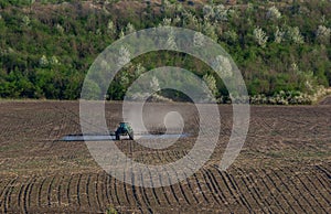 Tractor spray fertilizer spraying pesticides on green field, agriculture background concept