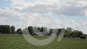 Tractor spray plant field near abandoned village with chemicals