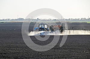 The tractor sprayed herbicides on the field. Chemistry in agricu