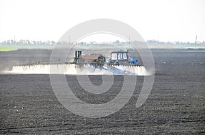 The tractor sprayed herbicides on the field. Chemistry in agricu