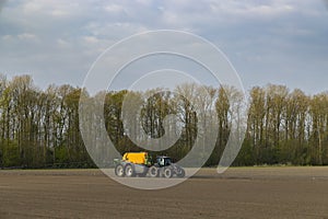 Tractor with a sprayer during spring work in the field