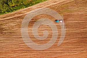 Tractor spraying crops in field, aerial view