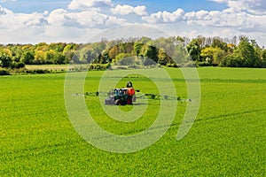 Tractor spraying glyphosate pesticides on a field
