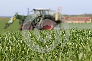 Tractor spraying green field - agriculture background