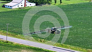 Tractor spraying pesticide fertilizer on farm field. Agricultural machinery at work