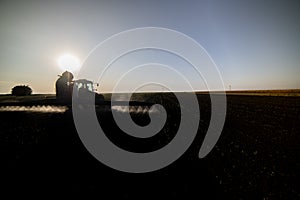 Tractor spraying pesticides on field with sprayer