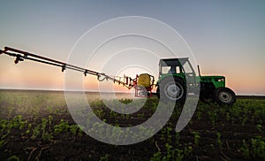 Tractor spraying pesticides at  soy bean field