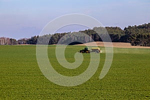 Tractor spraying pesticides on soybean field