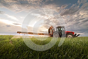 Tractor spraying pesticides at  wheat  field