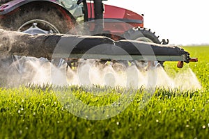 Tractor spraying pesticides wheat field