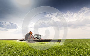 Tractor spraying pesticides wheat field