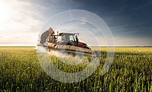 Tractor spraying pesticides wheat field