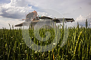 Tractor spraying pesticides wheat field