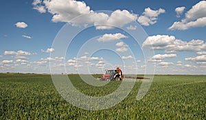 Tractor spraying pesticides wheat field photo