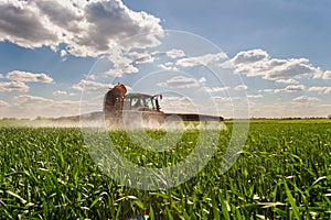 Tractor spraying pesticides wheat field photo