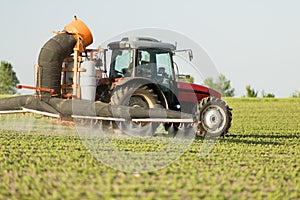 Tractor spraying soybean crops field