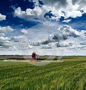 Tractor spraying soybean crops field