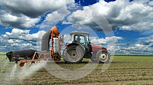 Tractor spraying soybean crops field