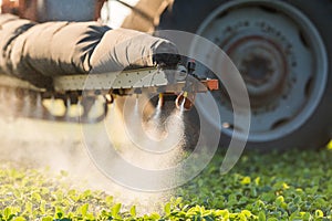 Tractor spraying soybean field at spring