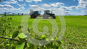 tractor sprays fertilizer on the field