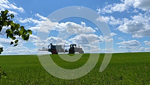 tractor sprays fertilizer on the field