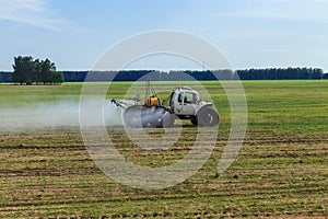 Tractor sprays liquid chemical fertilizers photo