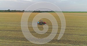 A tractor sprays wheat with herbicides. The tractor sprays the wheat fields. Spraying a field with wheat view from a