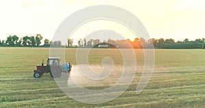 A tractor sprays wheat with herbicides. The tractor sprays the wheat fields. Spraying a field with wheat view from a