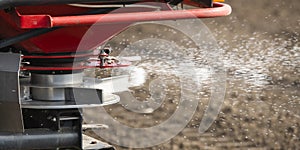 Tractor spreading artificial fertilizers in field