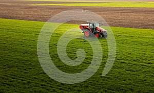 Tractor spreading artificial fertilizers in field