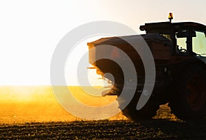 Tractor spreading artificial fertilizers in field