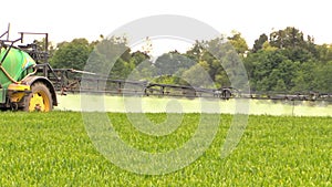 Tractor sprinkler spray field plants with chemical herbicide