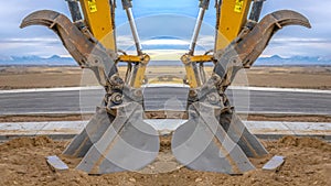 Tractor symmetry with open scooper on an excavator facing away