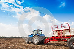 Tractor with tanks in the field. Sowing complex. Agricultural machinery and farming.